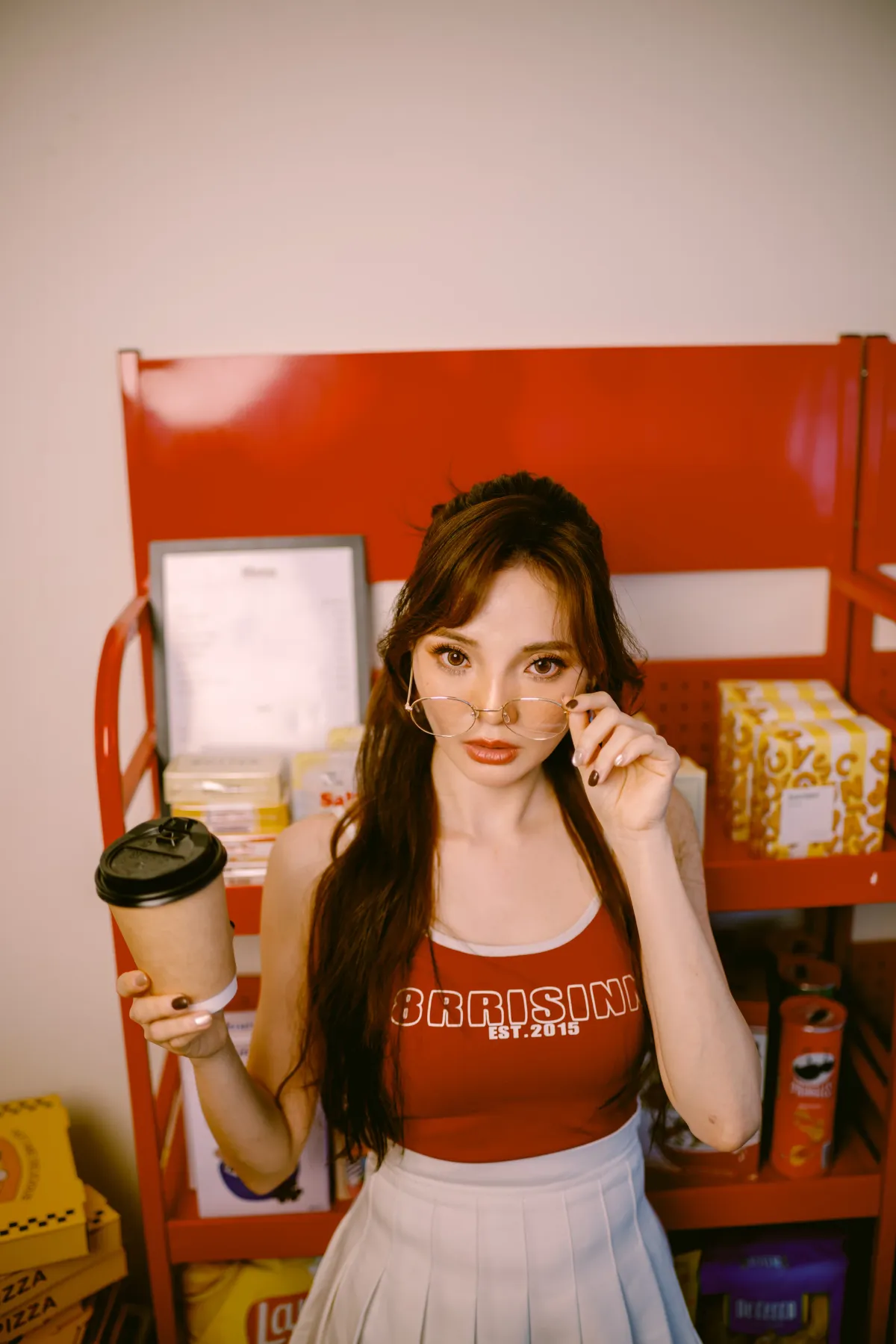 Ashley 手持咖啡、站在紅色貨架前的美式人像攝影